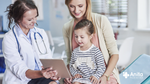 Uma imagem contendo uma médica, uma criança com sua mãe, no consultório pediatra para consulta
