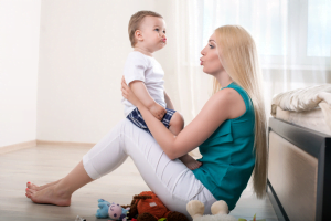 Um bebê com sua mãe sentados no chão com um sofá ao lado para artigo sobre fala